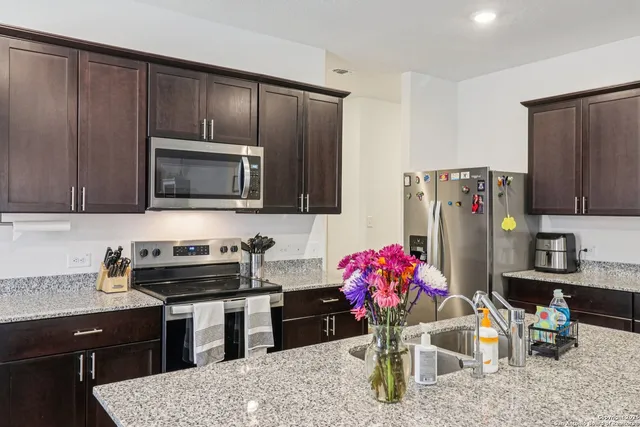 a kitchen with stainless steel appliances granite countertop a refrigerator sink and cabinets