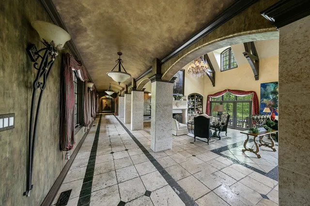 a outdoor dining area with lots of tables a chandelier and chairs