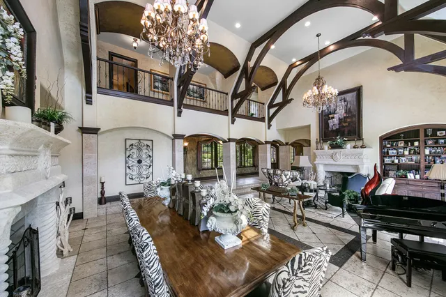a living room with furniture a fireplace and a dining table with wooden floor