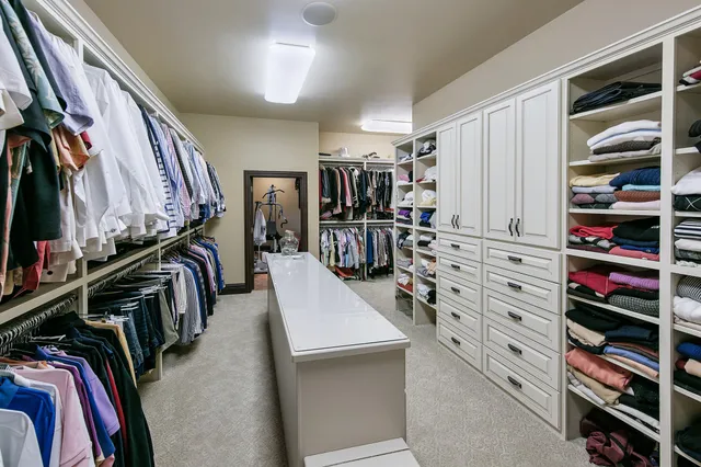 a view of a swimming pool with lawn chairs and potted plants