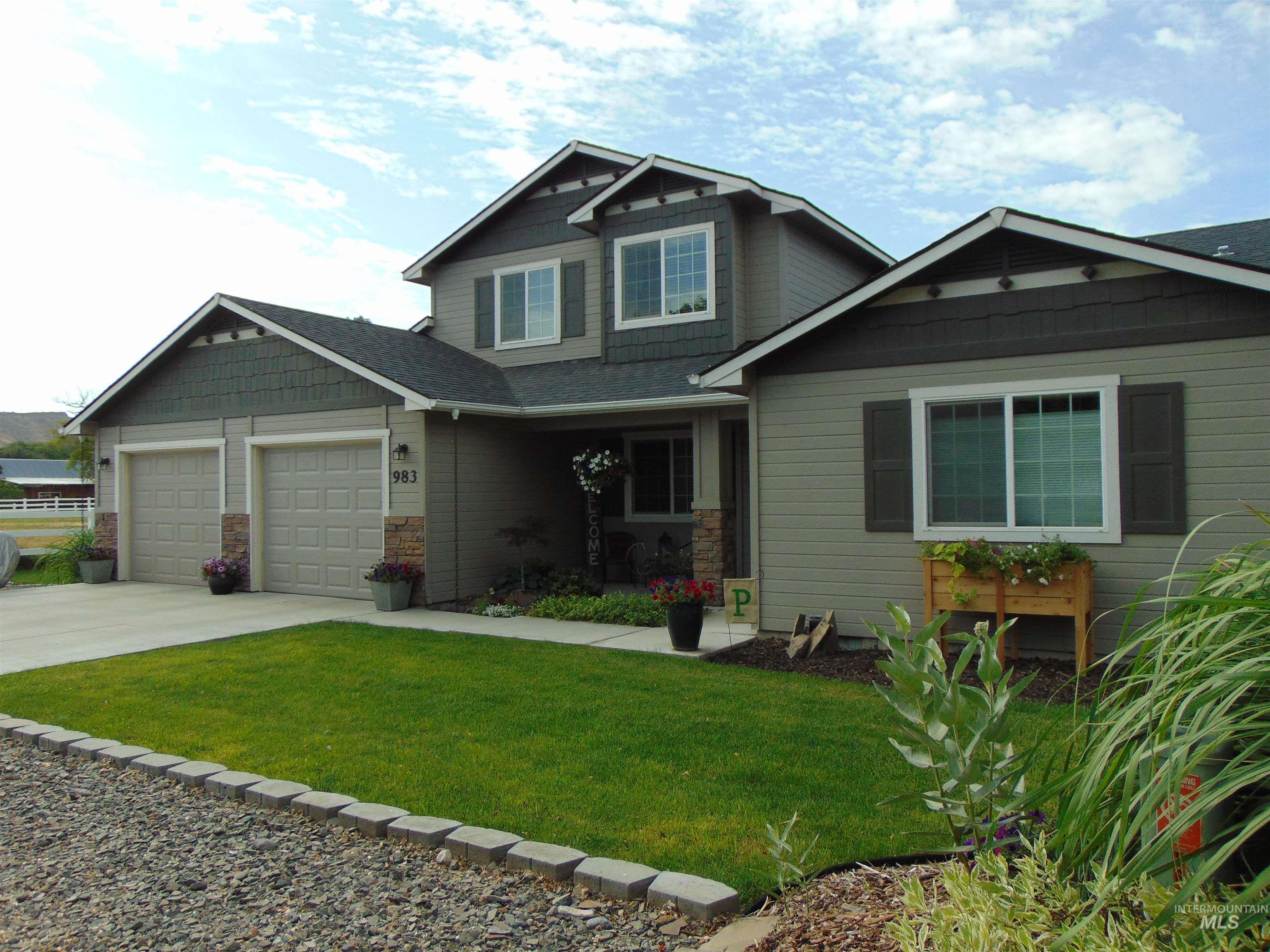 Craftsman house with concrete driveway, a front yard, an attached garage, and stone siding