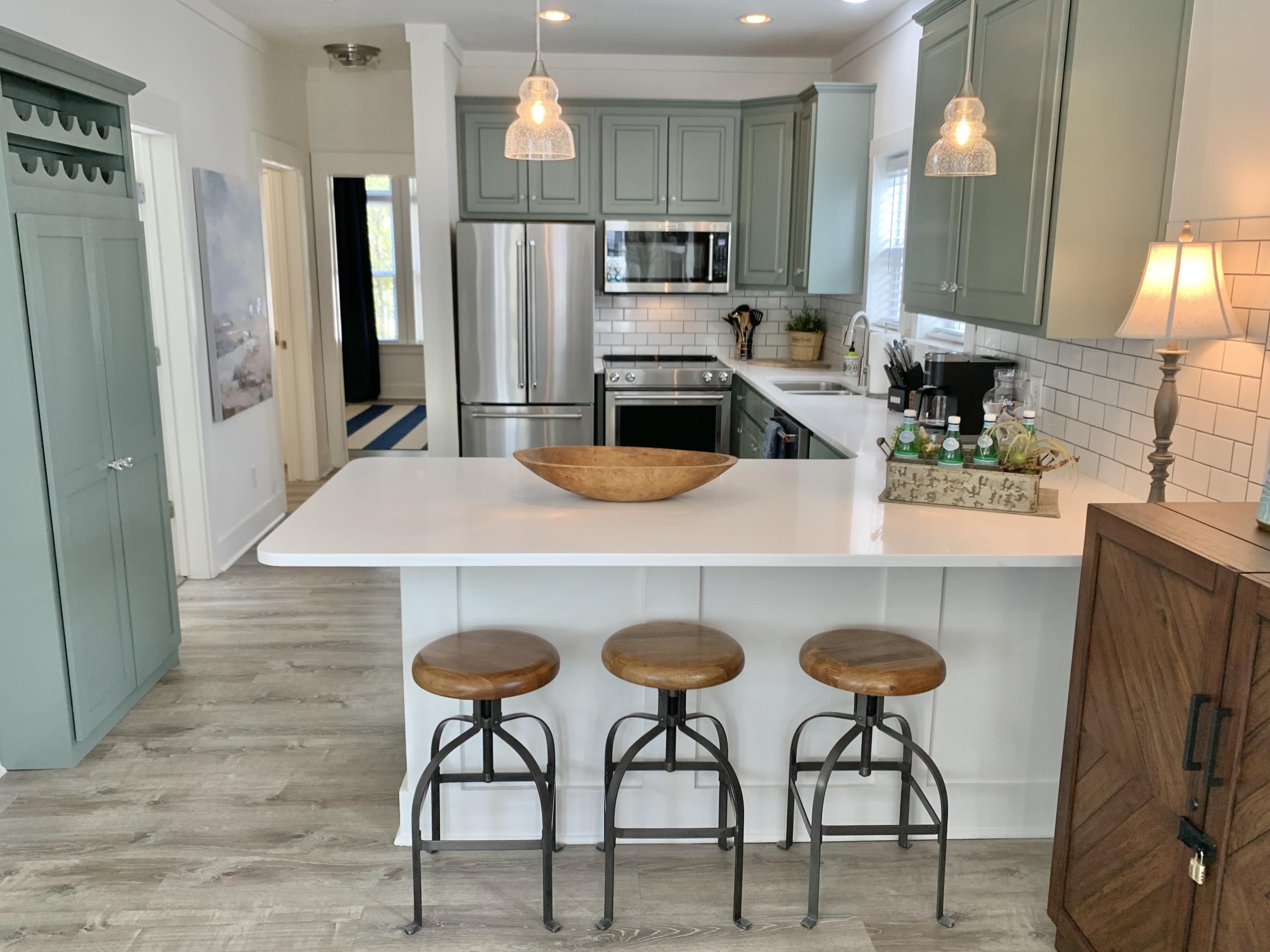 60 The Greenway Loop Inlet Beach, FL 32461 - Photo 19 of 35 a kitchen with stainless steel appliances kitchen island a table and chairs in it