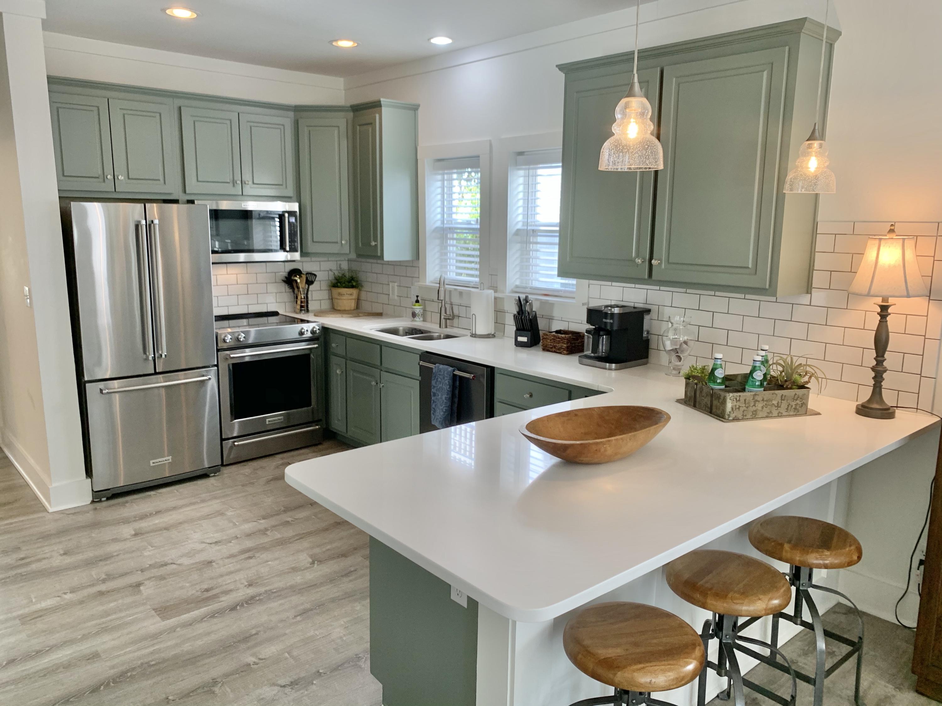 60 The Greenway Loop Inlet Beach, FL 32461 - Photo 9 of 35 a kitchen with granite countertop kitchen island stainless steel appliances a sink and refrigerator