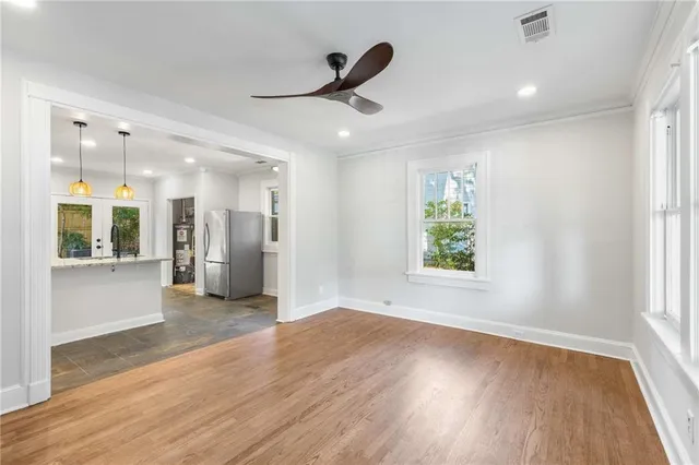 a view of an empty room with wooden floor and a window