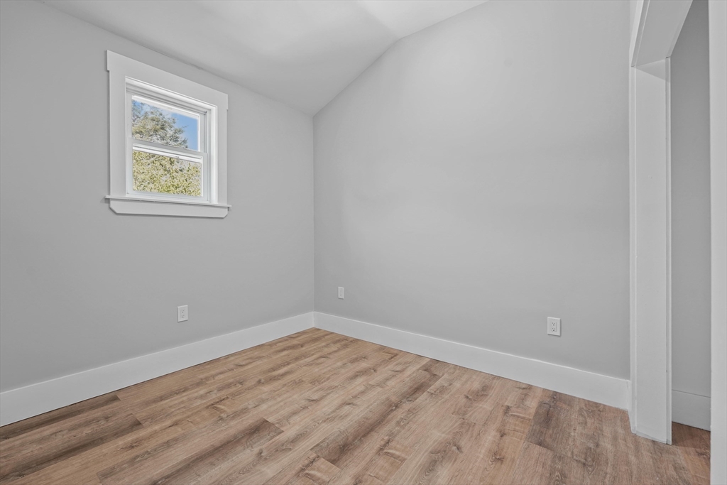 19-21 Standard Street, Unit 3 Boston, MA 02126 - Photo 19 of 23 a view of an empty room with wooden floor and a window