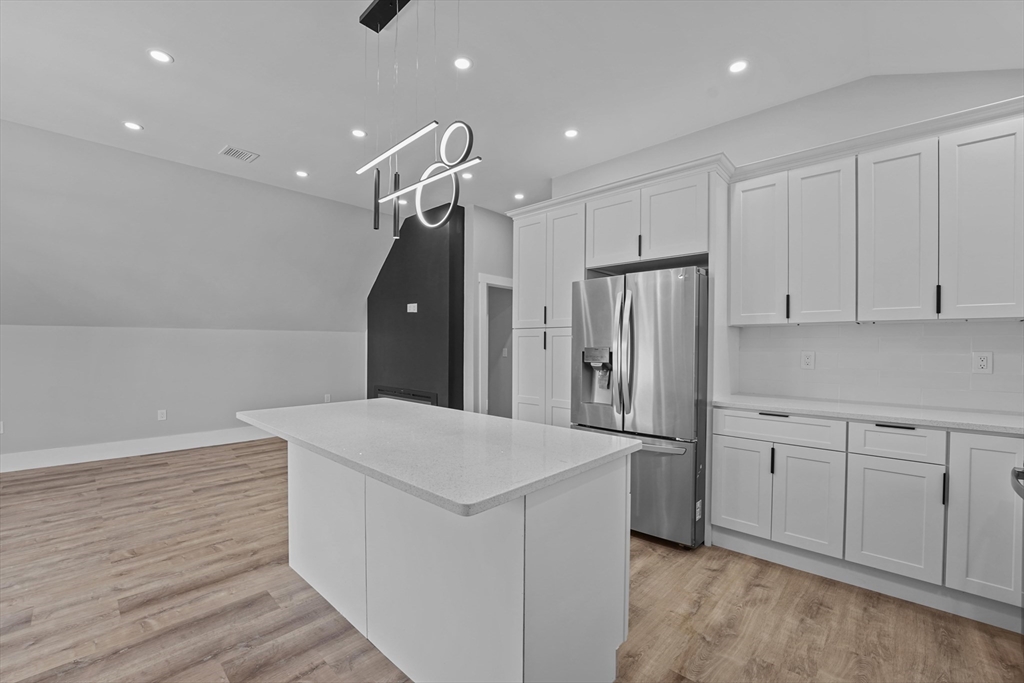 19-21 Standard Street, Unit 3 Boston, MA 02126 - Photo 6 of 23 a kitchen with white cabinets and refrigerator