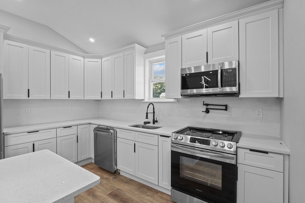 19-21 Standard Street, Unit 3 Boston, MA 02126 - Photo 7 of 23 a kitchen with cabinets stainless steel appliances and a sink