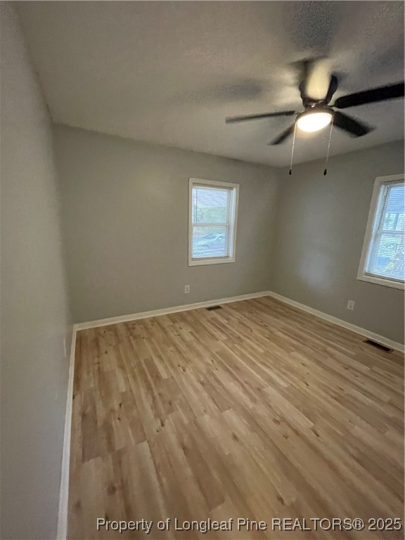 1106 Simpson Street Fayetteville, NC 28305 - Photo 14 of 14 an empty room with wooden floor and windows