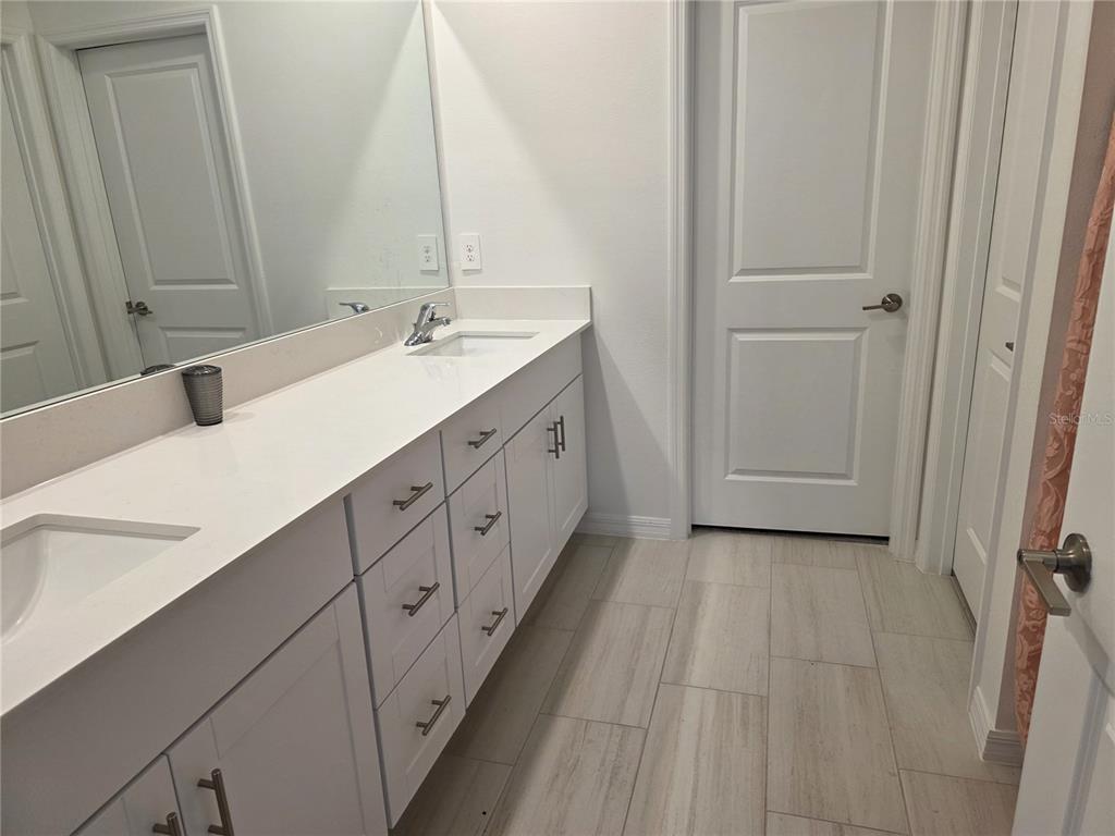 12588 Timber Moss Lane Riverview, FL 33579 - Photo 6 of 10 a spacious bathroom with a double vanity sink and mirror