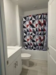 a bathroom with a toilet and a shower curtain