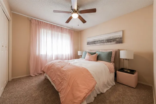 a spacious bedroom with a bed and a chandelier
