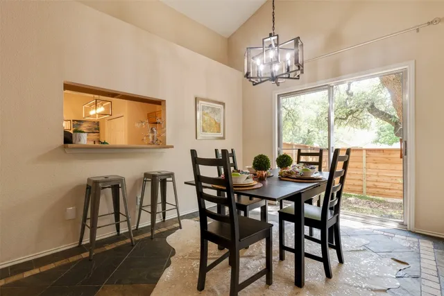 a view of a dining room with furniture a chandelier and wooden floor