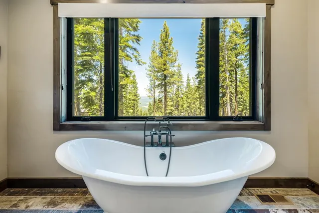 a white bath tub sitting in a bathroom next to a window