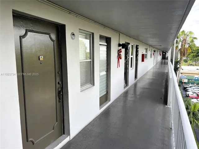 a hallway with wooden floor and stairs