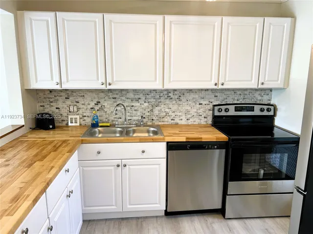 a kitchen with granite countertop white cabinets and white appliances