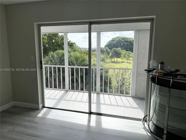 a view of a porch with wooden floor and a floor to ceiling window