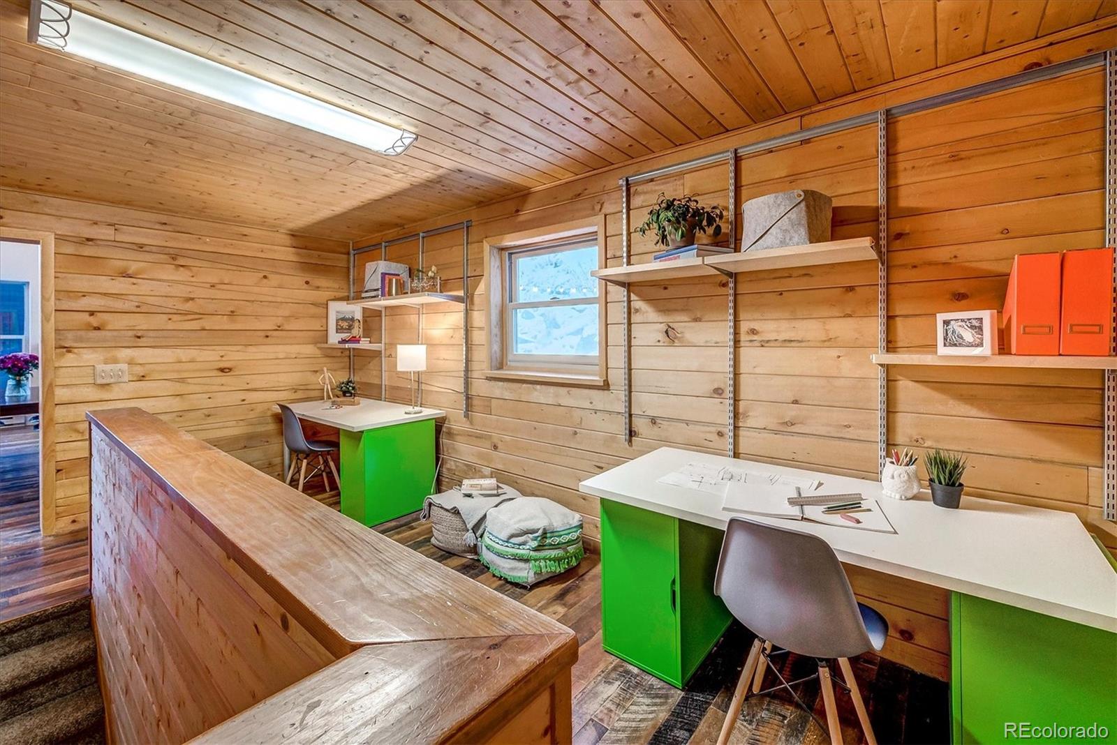 9055 Eagle Cliff Road Conifer, CO 80433 - Photo 14 of 39 a view of a patio with table and chairs with wooden floor and fence