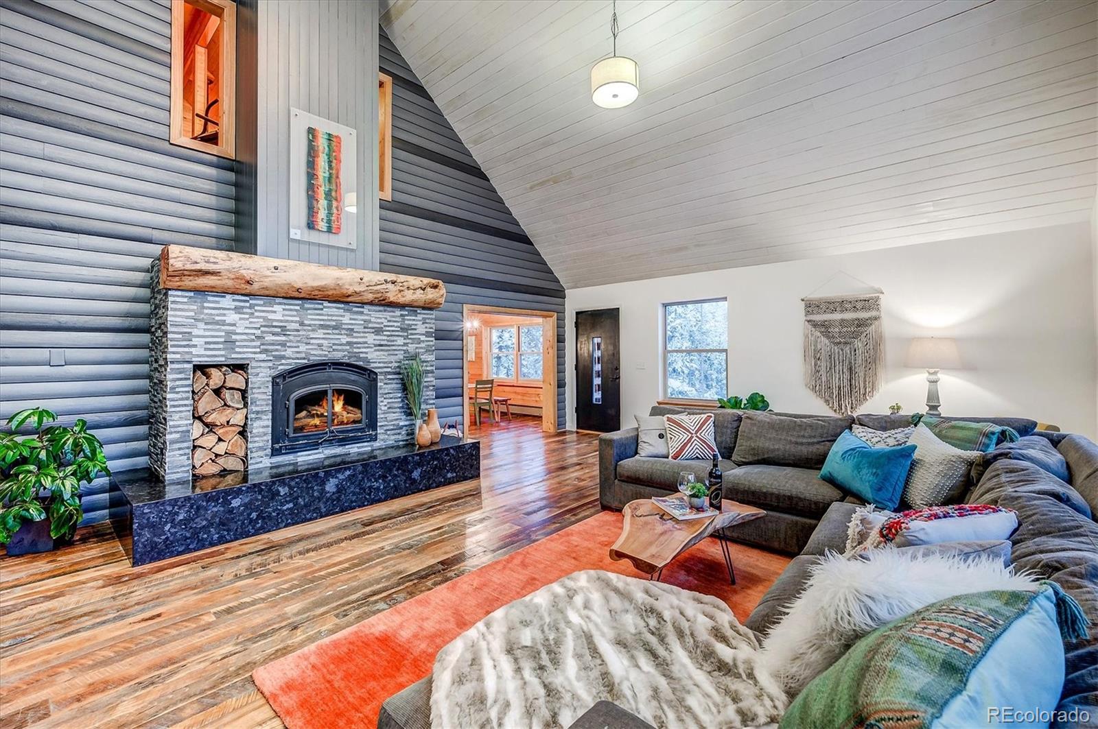 9055 Eagle Cliff Road Conifer, CO 80433 - Photo 3 of 39 a living room with furniture and a fireplace