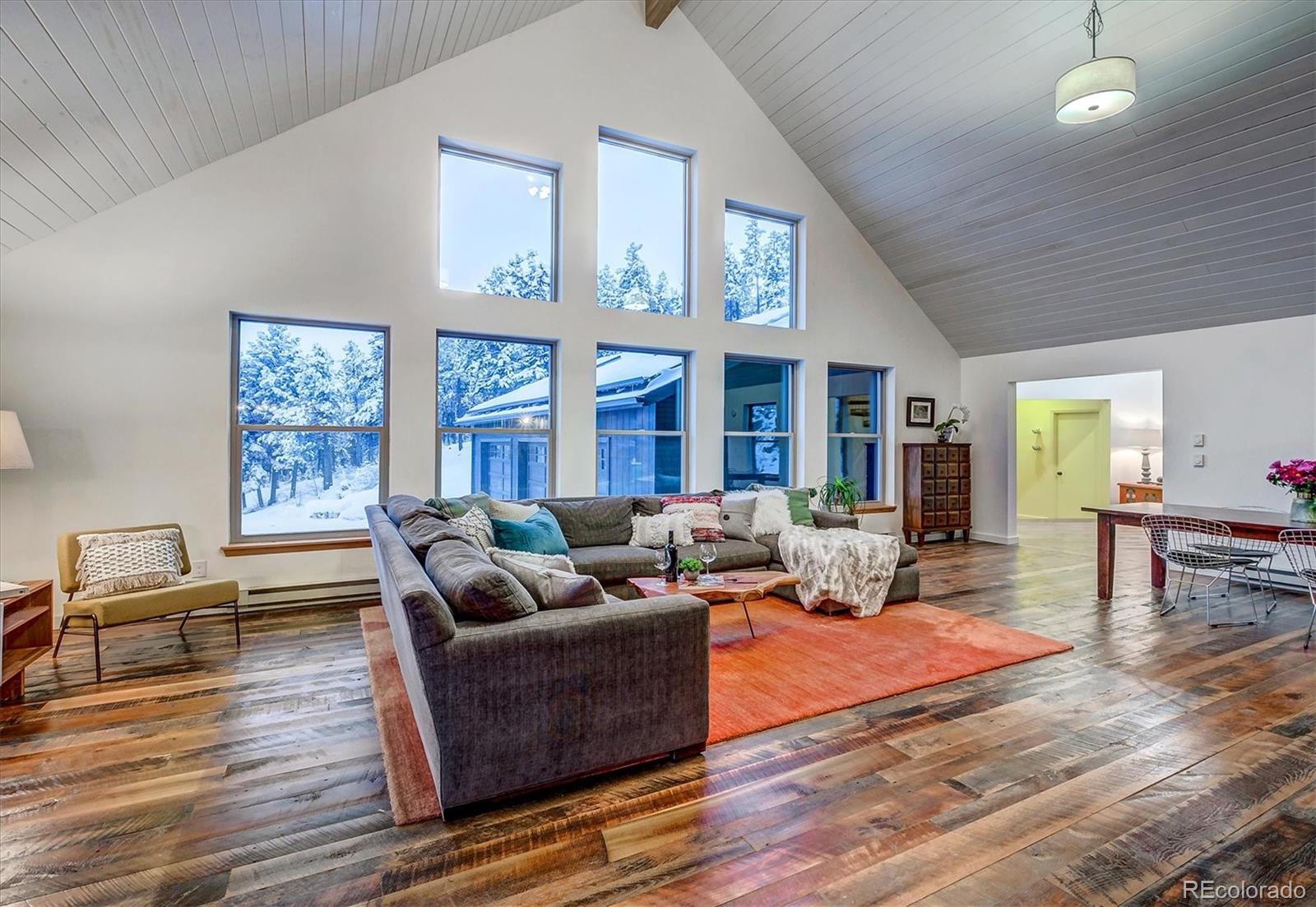 9055 Eagle Cliff Road Conifer, CO 80433 - Photo 5 of 39 a living room with furniture wooden floor and large window