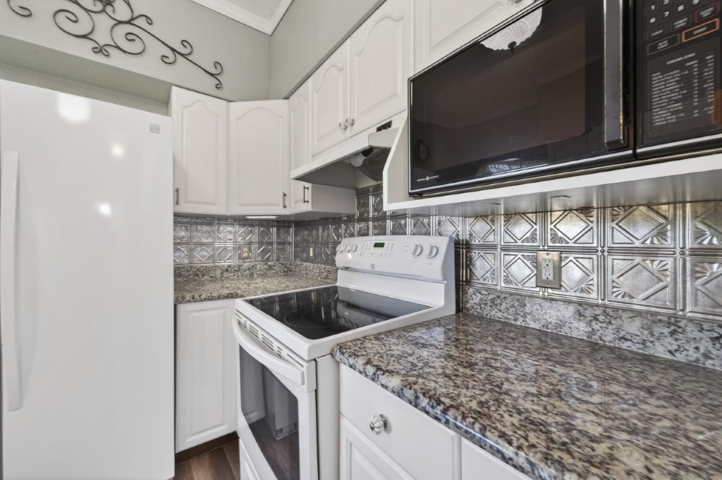 6610 Sprigg Street Fulshear, TX 77441 - Photo 17 of 49 a kitchen with a stove and a microwave
