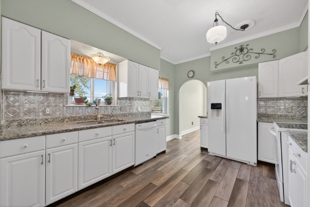 6610 Sprigg Street Fulshear, TX 77441 - Photo 21 of 49 a kitchen with granite countertop white cabinets white appliances a sink and a large window