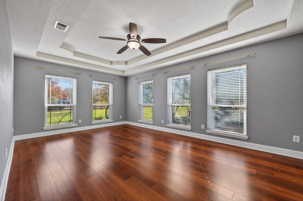 6610 Sprigg Street Fulshear, TX 77441 - Photo 22 of 49 a view of an empty room with wooden floor and a window