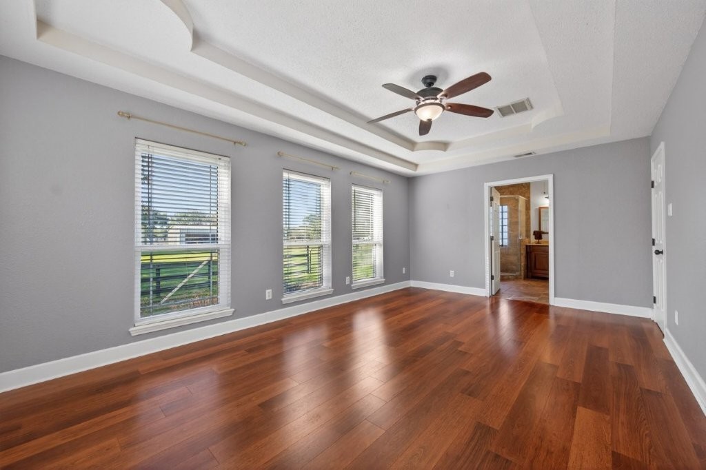 6610 Sprigg Street Fulshear, TX 77441 - Photo 23 of 49 a view of an empty room with wooden floor and a window