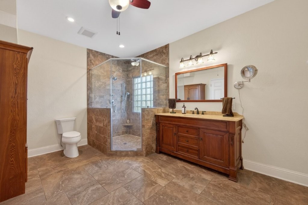 6610 Sprigg Street Fulshear, TX 77441 - Photo 25 of 49 a spacious bathroom with a double vanity sink a mirror and a toilet