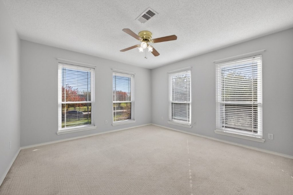 6610 Sprigg Street Fulshear, TX 77441 - Photo 28 of 49 a view of an empty room with a window and a kitchen
