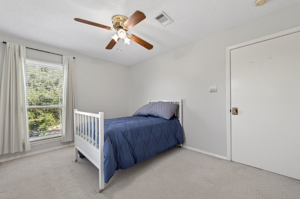 6610 Sprigg Street Fulshear, TX 77441 - Photo 34 of 49 a bed room with a bed and a chandelier