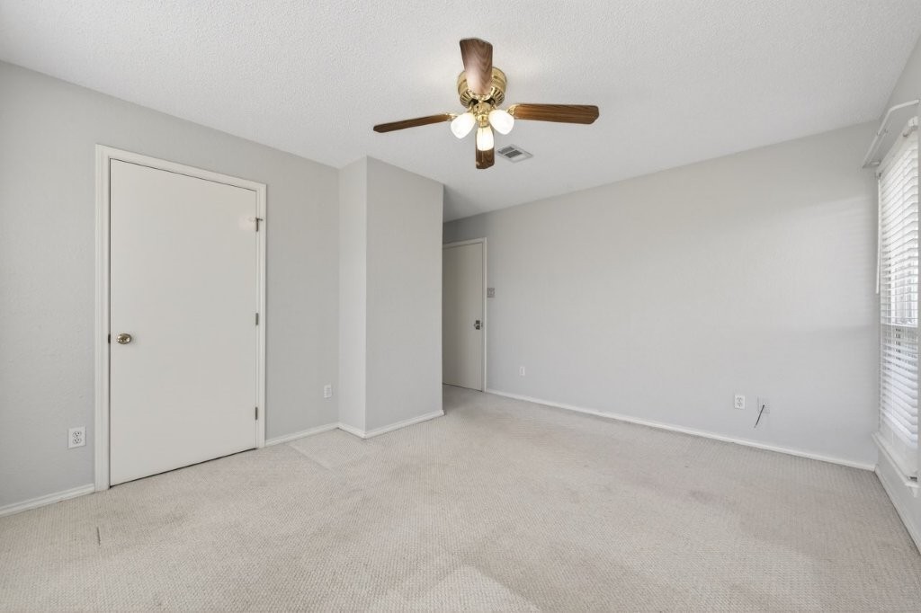 6610 Sprigg Street Fulshear, TX 77441 - Photo 37 of 49 an empty room with a chandelier fan and windows