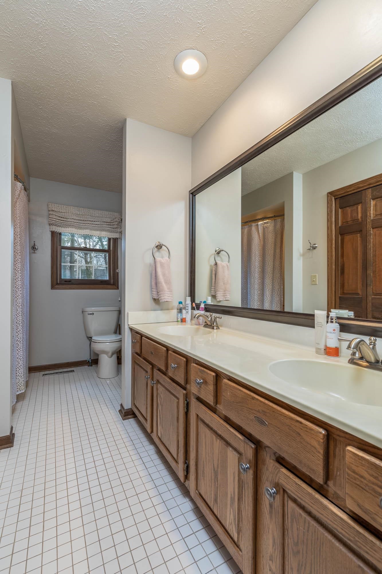 7113 Sentinel Road Rockford, IL 61107 - Photo 26 of 38 a spacious bathroom with a double vanity sink and a mirror