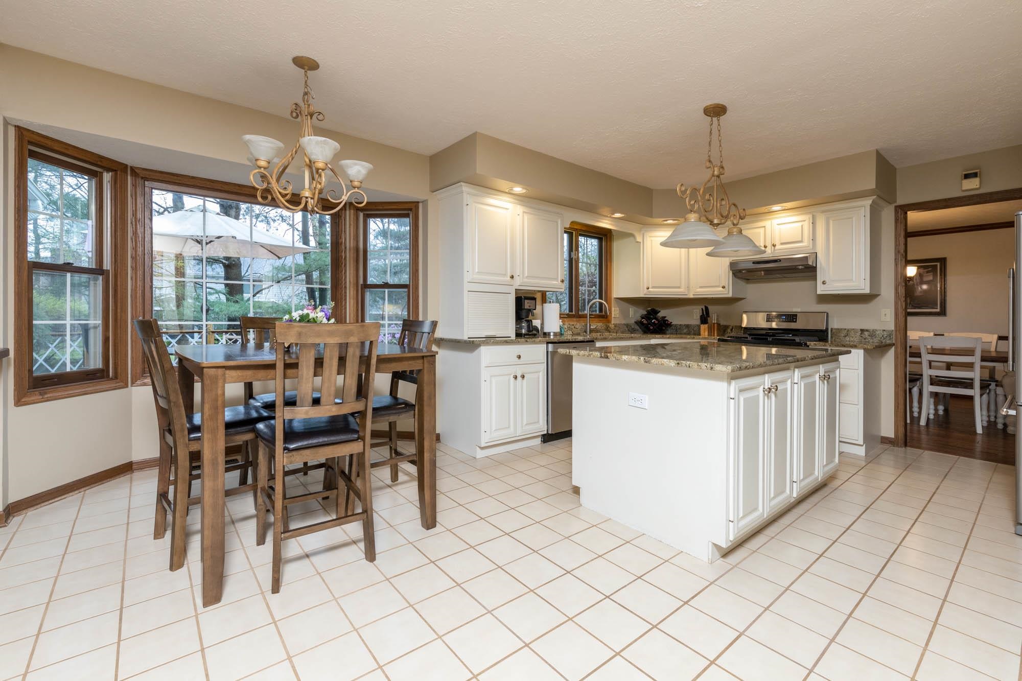 7113 Sentinel Road Rockford, IL 61107 - Photo 10 of 38 a kitchen with stainless steel appliances granite countertop a stove top oven a sink a dining table and chairs