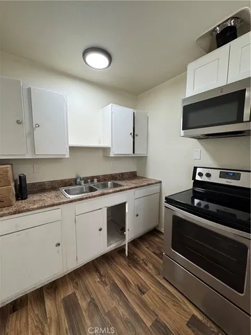 a kitchen with granite countertop a stove cabinets and microwave