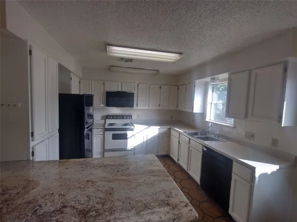 a large kitchen with a stove top oven a sink and dishwasher