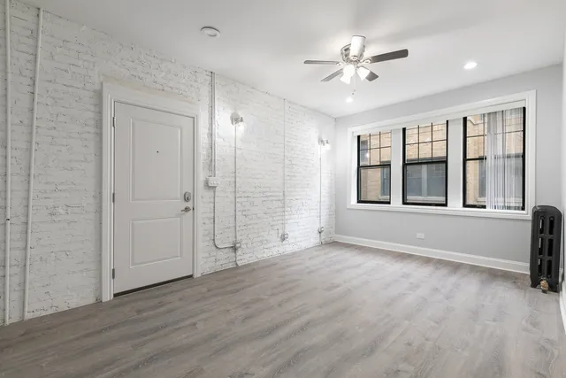 a view of an empty room with a window and a kitchen