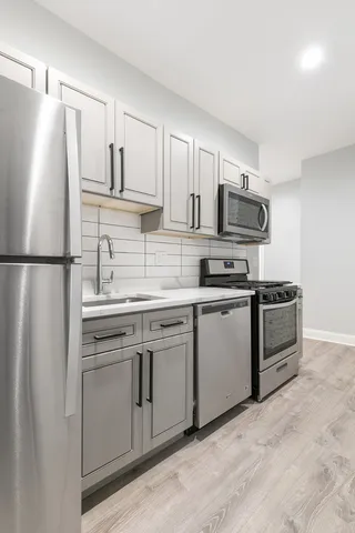 a kitchen with stainless steel appliances a refrigerator sink and microwave