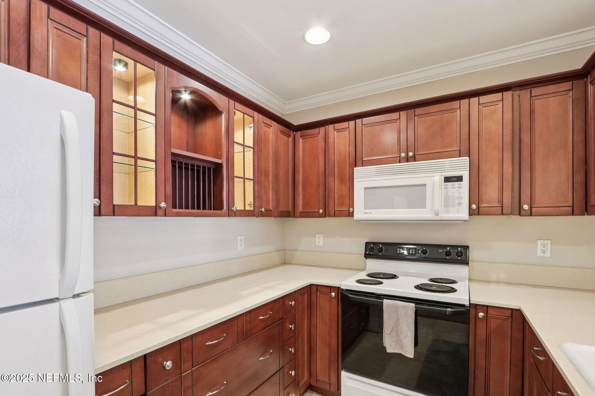 1810 Sevilla Boulevard West, Unit 307 Atlantic Beach, FL 32233 - Photo 13 of 28 a kitchen with stainless steel appliances granite countertop a stove a sink and a microwave