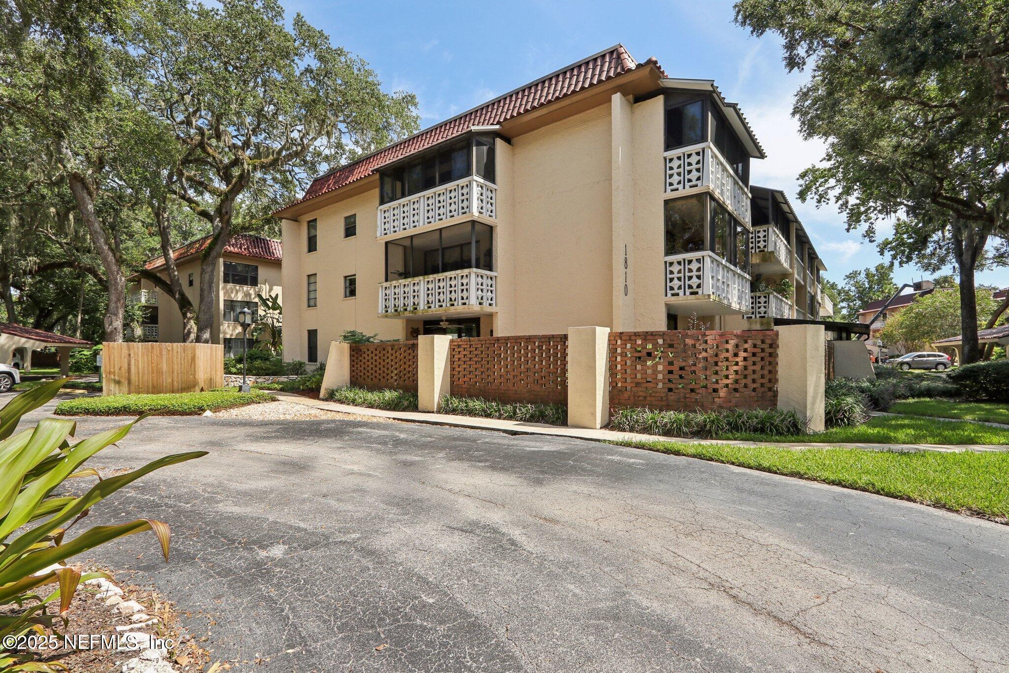 1810 Sevilla Boulevard West, Unit 307 Atlantic Beach, FL 32233 - Photo 25 of 28 a front view of a house with a yard and garage