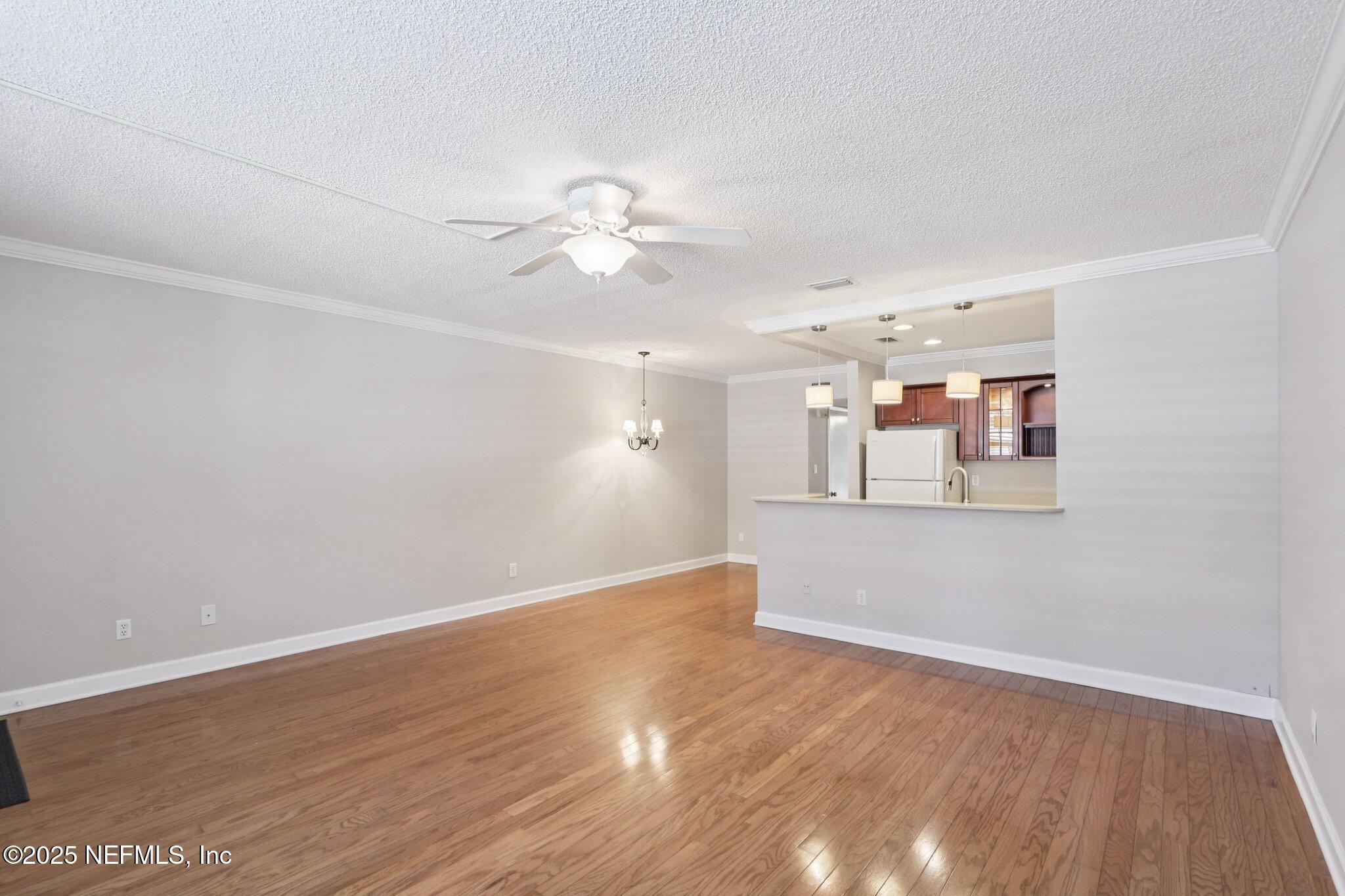 1810 Sevilla Boulevard West, Unit 307 Atlantic Beach, FL 32233 - Photo 8 of 28 wooden floor in an empty room with a window