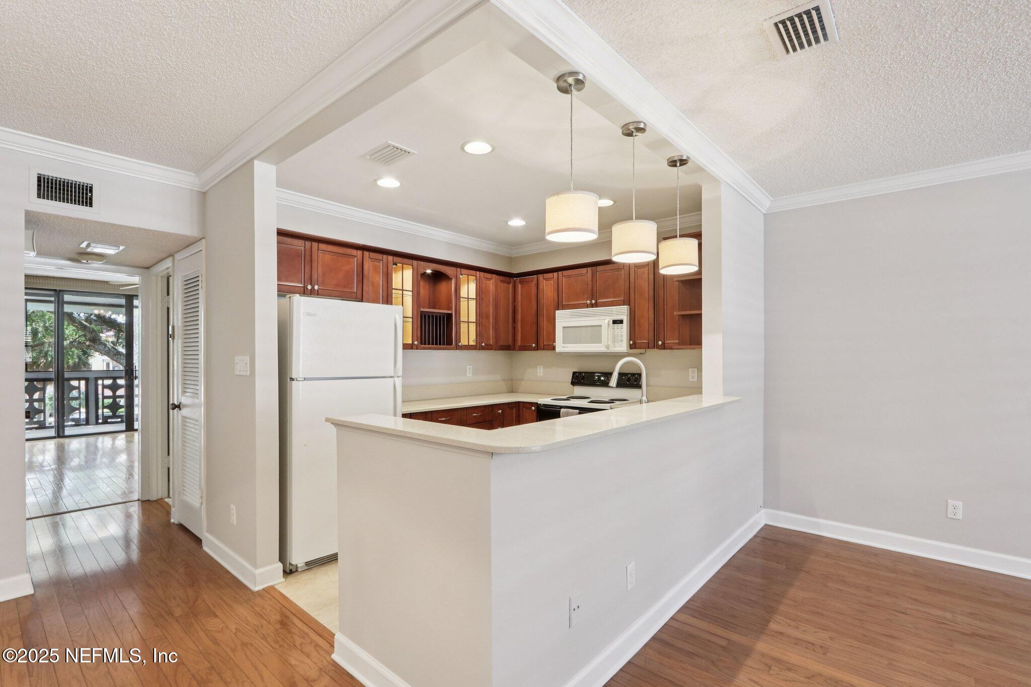 1810 Sevilla Boulevard West, Unit 307 Atlantic Beach, FL 32233 - Photo 9 of 28 a kitchen with a stove and a refrigerator