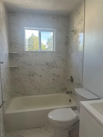 a bathroom with a toilet and a bath tub
