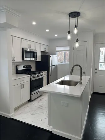 a kitchen with a sink stainless steel appliances and white cabinets