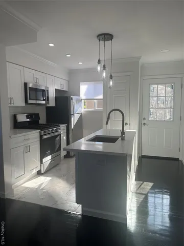 a kitchen with kitchen island a sink stainless steel appliances and cabinets
