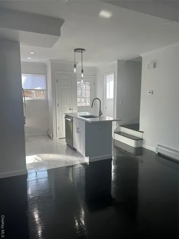 a view of a kitchen with kitchen island stainless steel appliances a sink stove and refrigerator