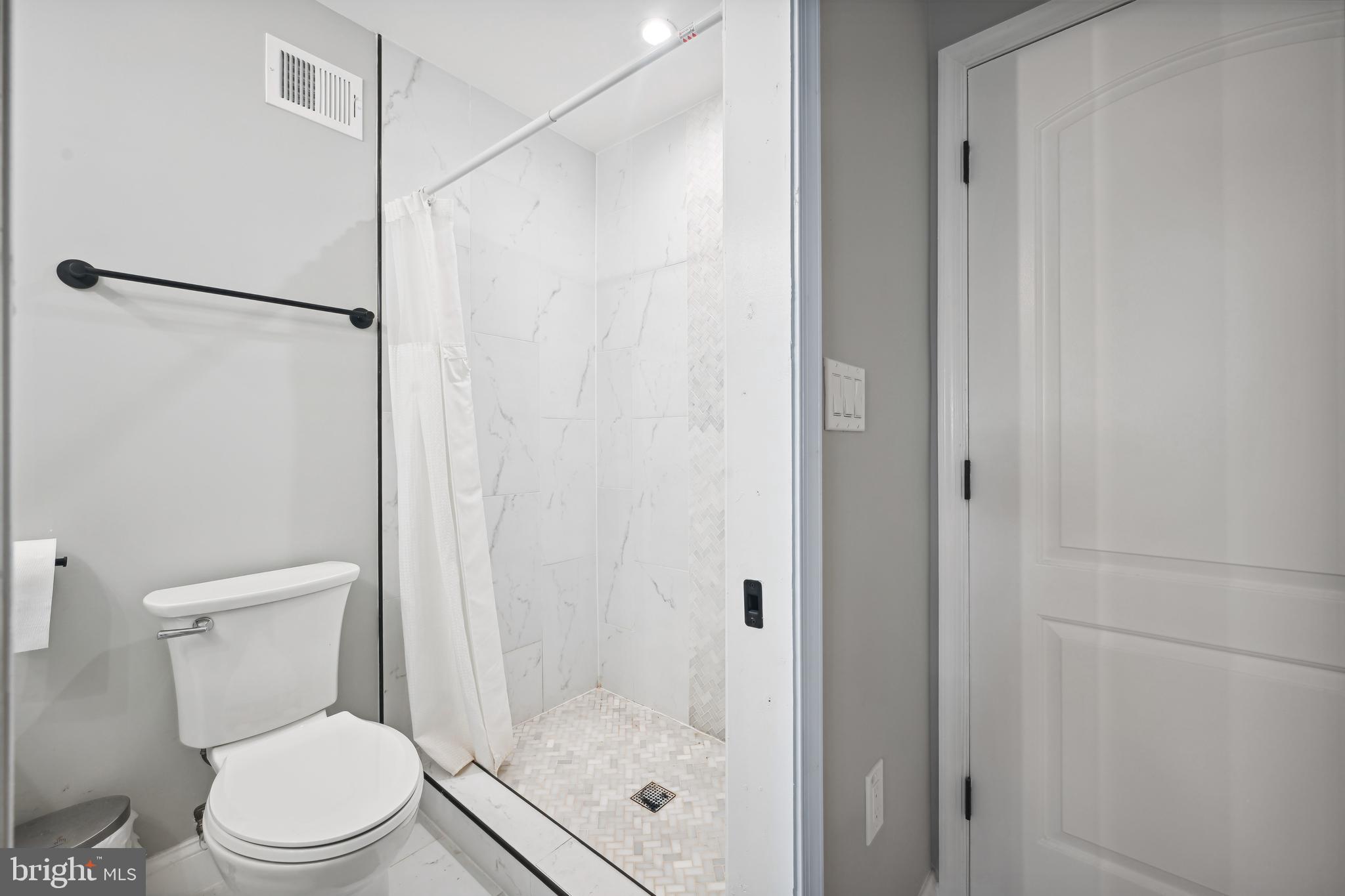 1732 L Street Northeast Washington, DC 20002 - Photo 16 of 20 a white toilet sitting next to a bathroom sink