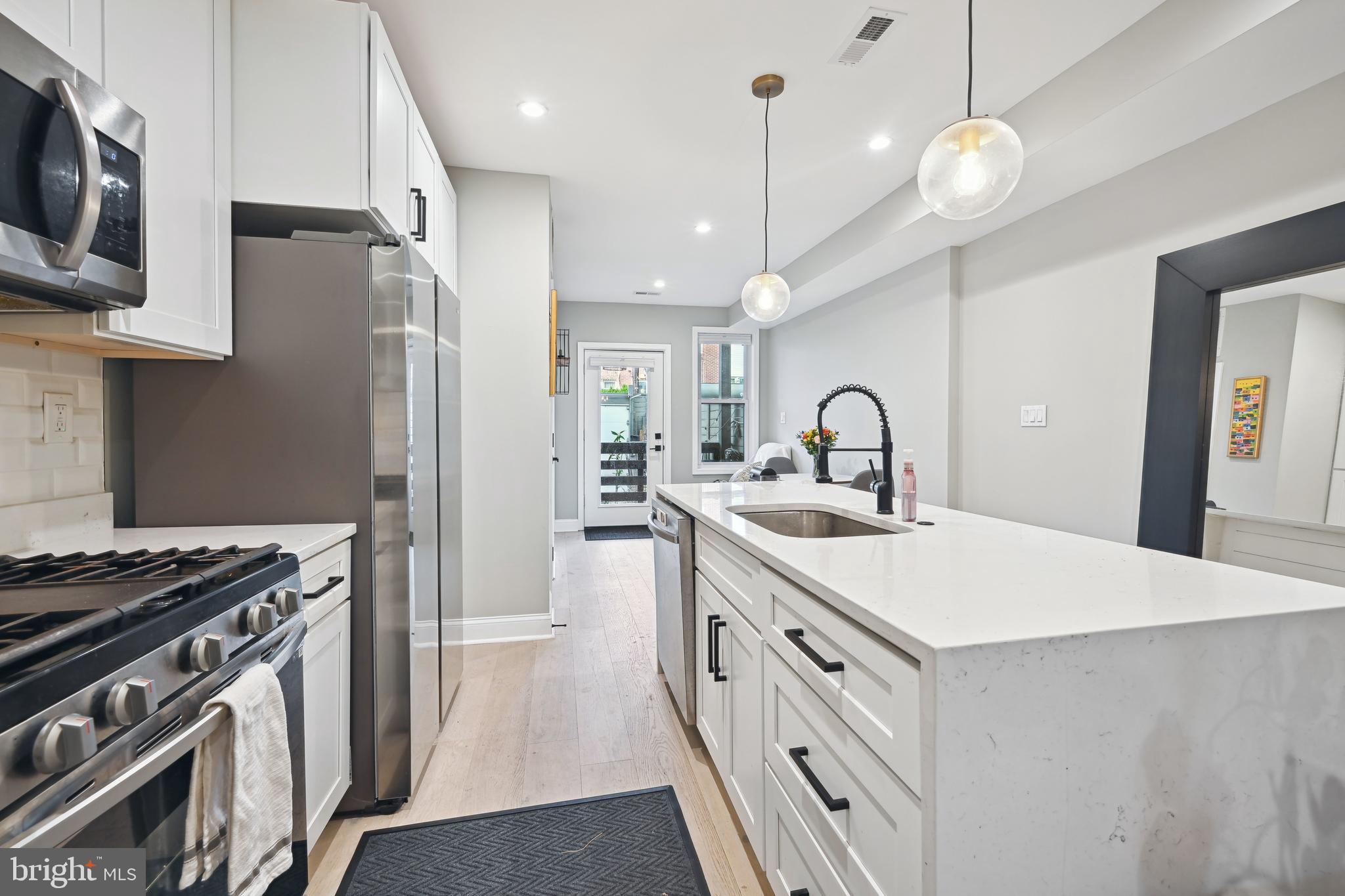 1732 L Street Northeast Washington, DC 20002 - Photo 8 of 20 a kitchen with stainless steel appliances a sink a stove a refrigerator and cabinets