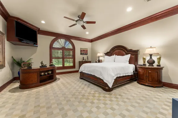 a spacious bedroom with a large bed and a flat tv screen on dresser