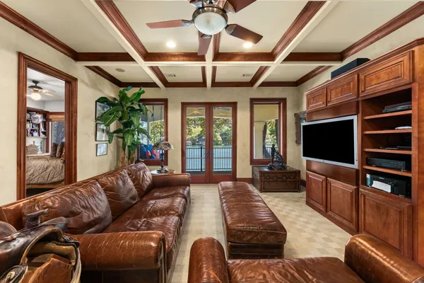 a living room with furniture a flat screen tv and a chandelier
