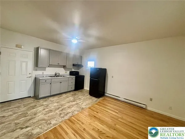 a kitchen with granite countertop a refrigerator stove top oven and sink